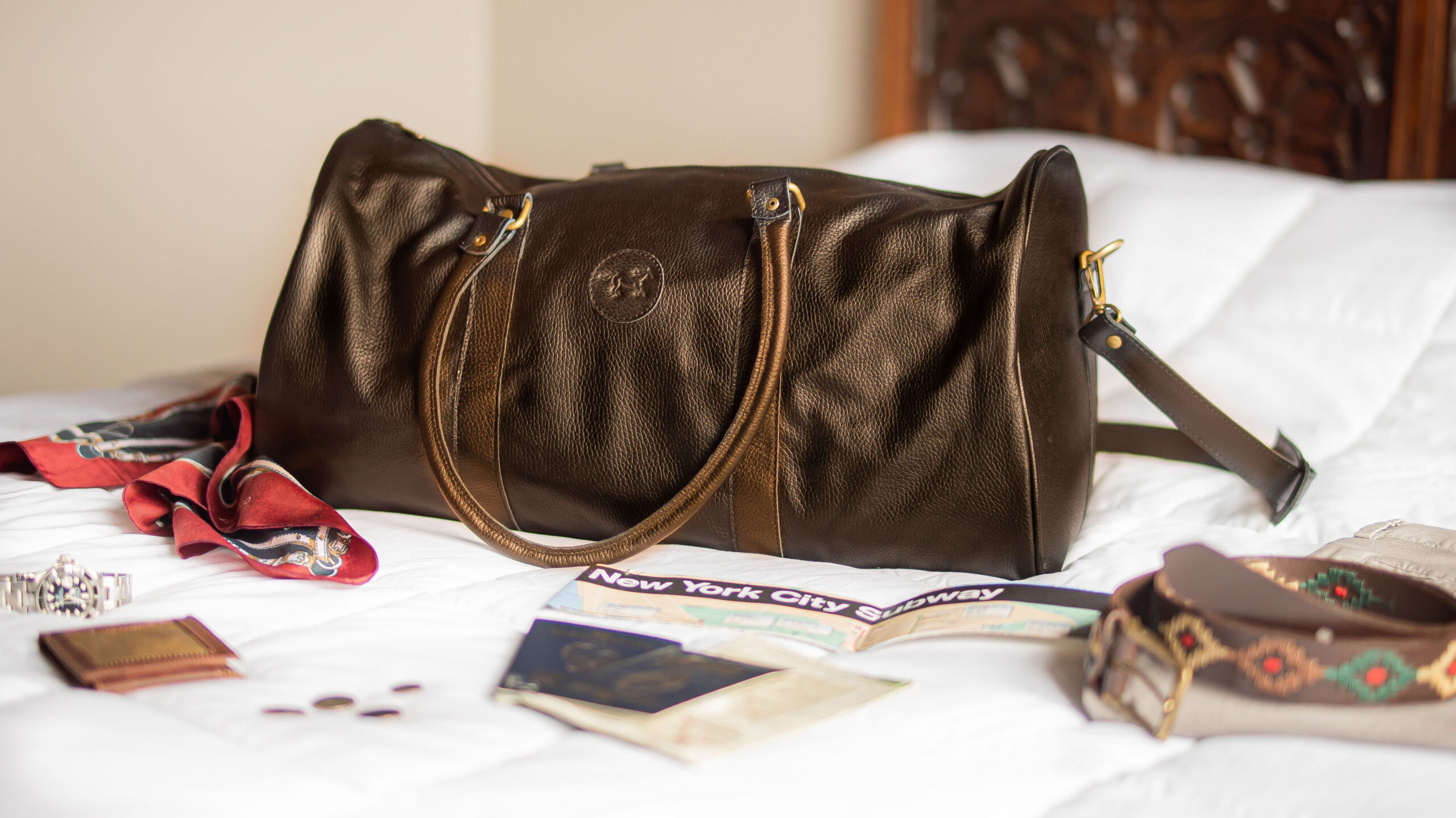 Bolso de viaje marrón actual sobre la cama