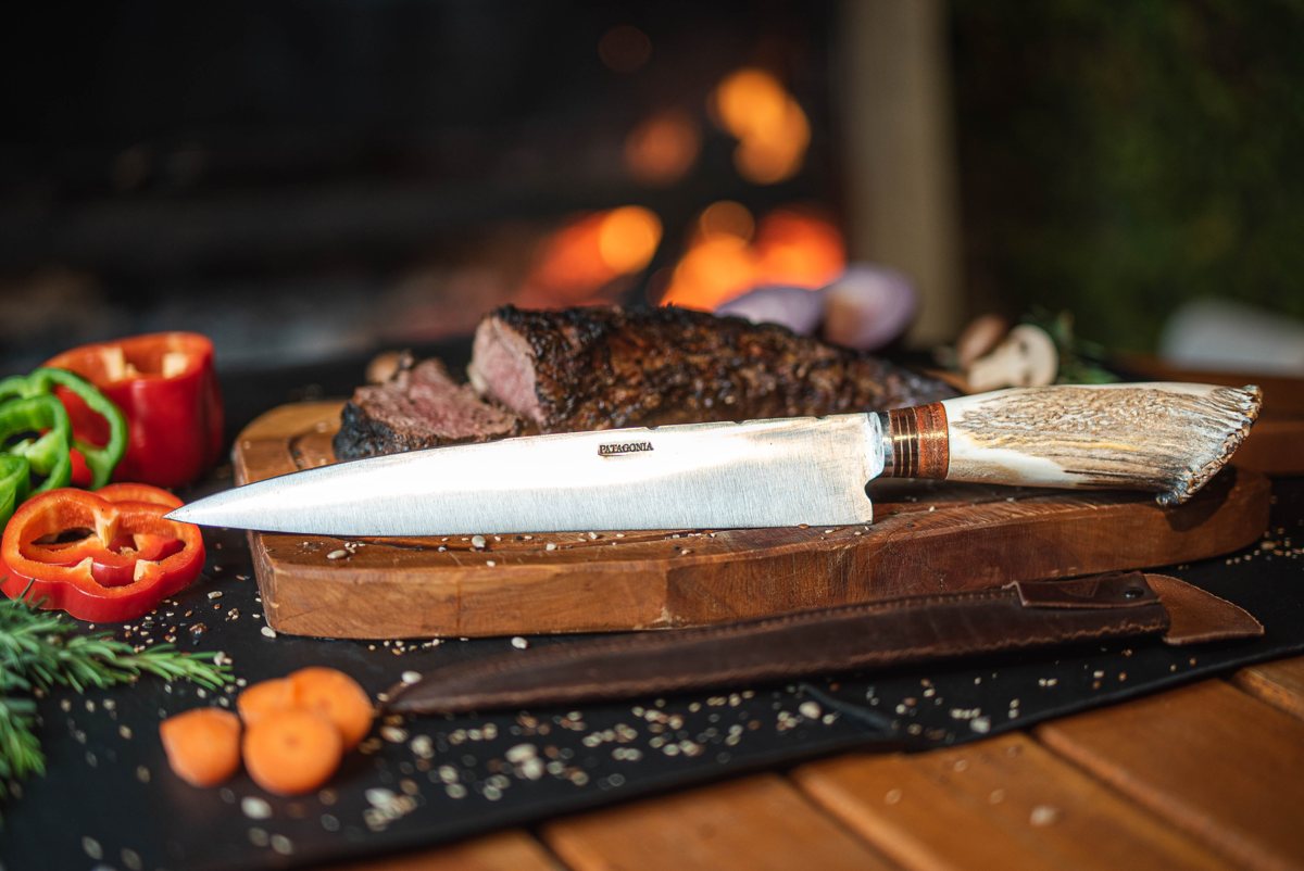 Cuchillo artesanal sobre tabla de asado